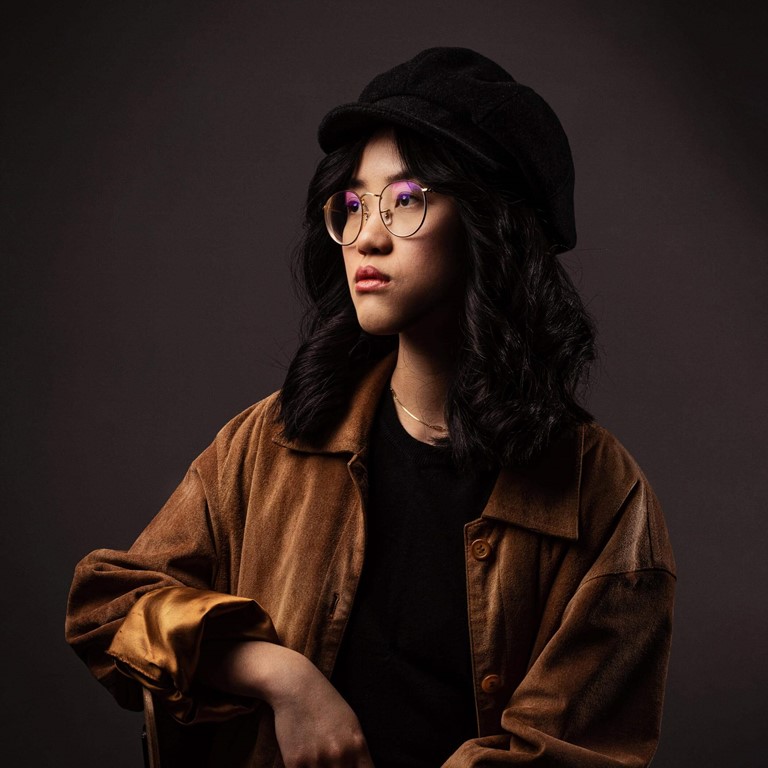 She's bold Eine asiatisch anmutende Frau mit schwarzen Haaren, Brille und Hut posiert im Stil alter Meister